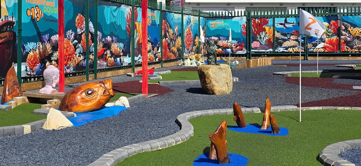 The finished nautical course at Maidenhead Aquatics St Albans, with carved timber fish, a boulder, boat and the reef mural along the fence