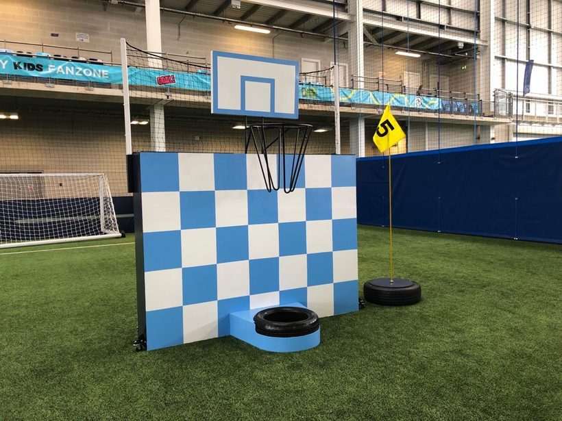 Sky blue and white chequerboard backboard obstacle beneath a basketball hoop